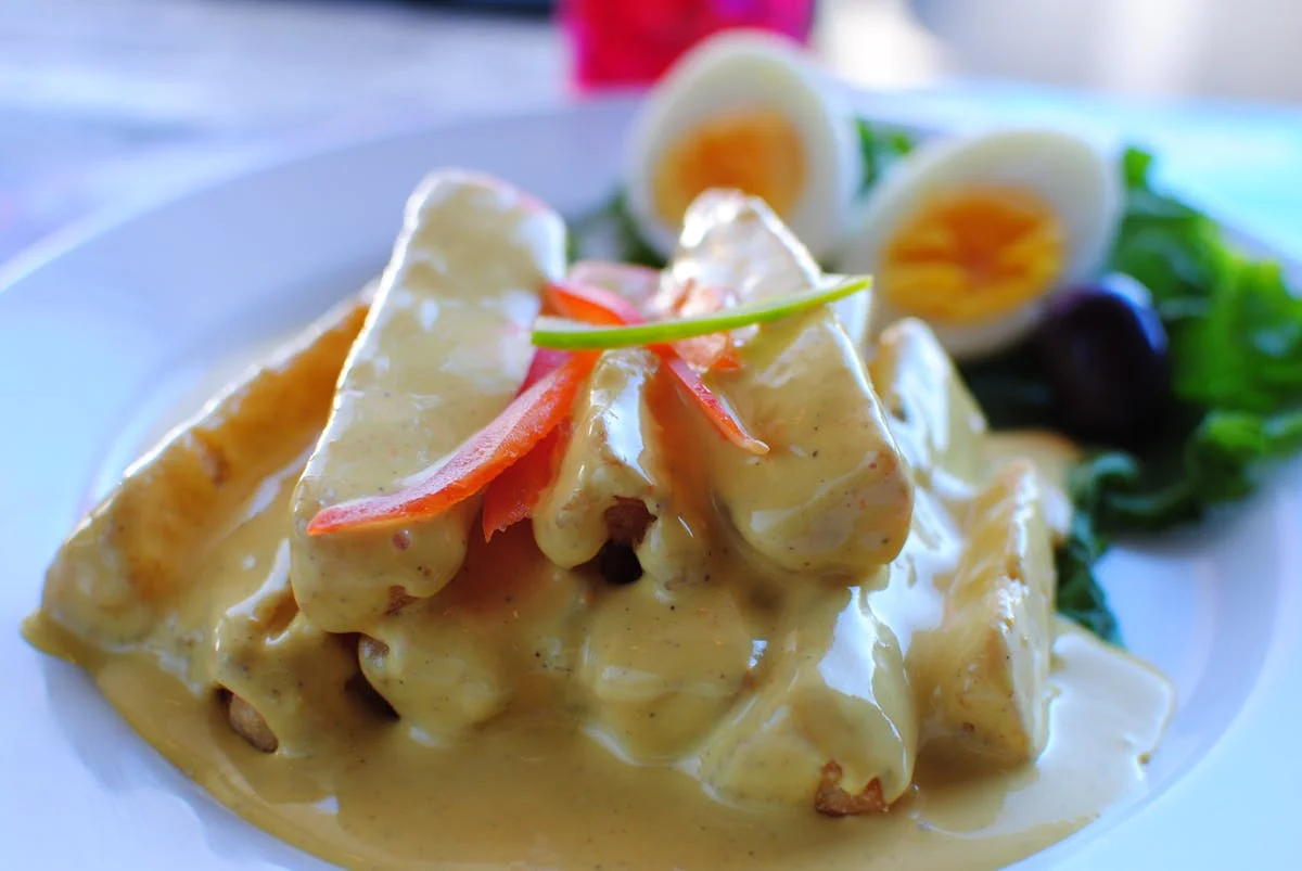 Peruvian causa rellena with creamy sauce and garnishes