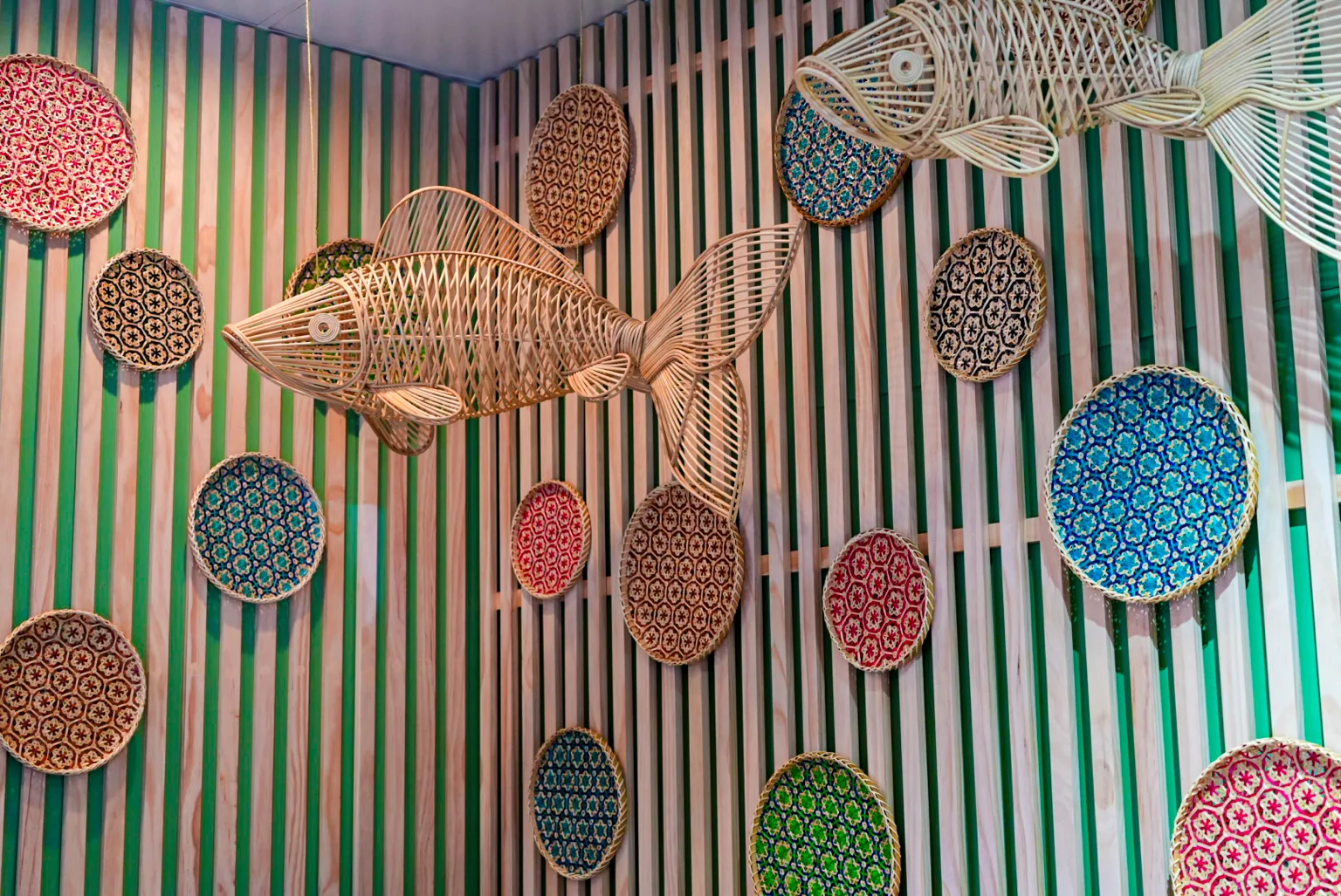 Artistic wall decor featuring woven fish and colorful circular patterns