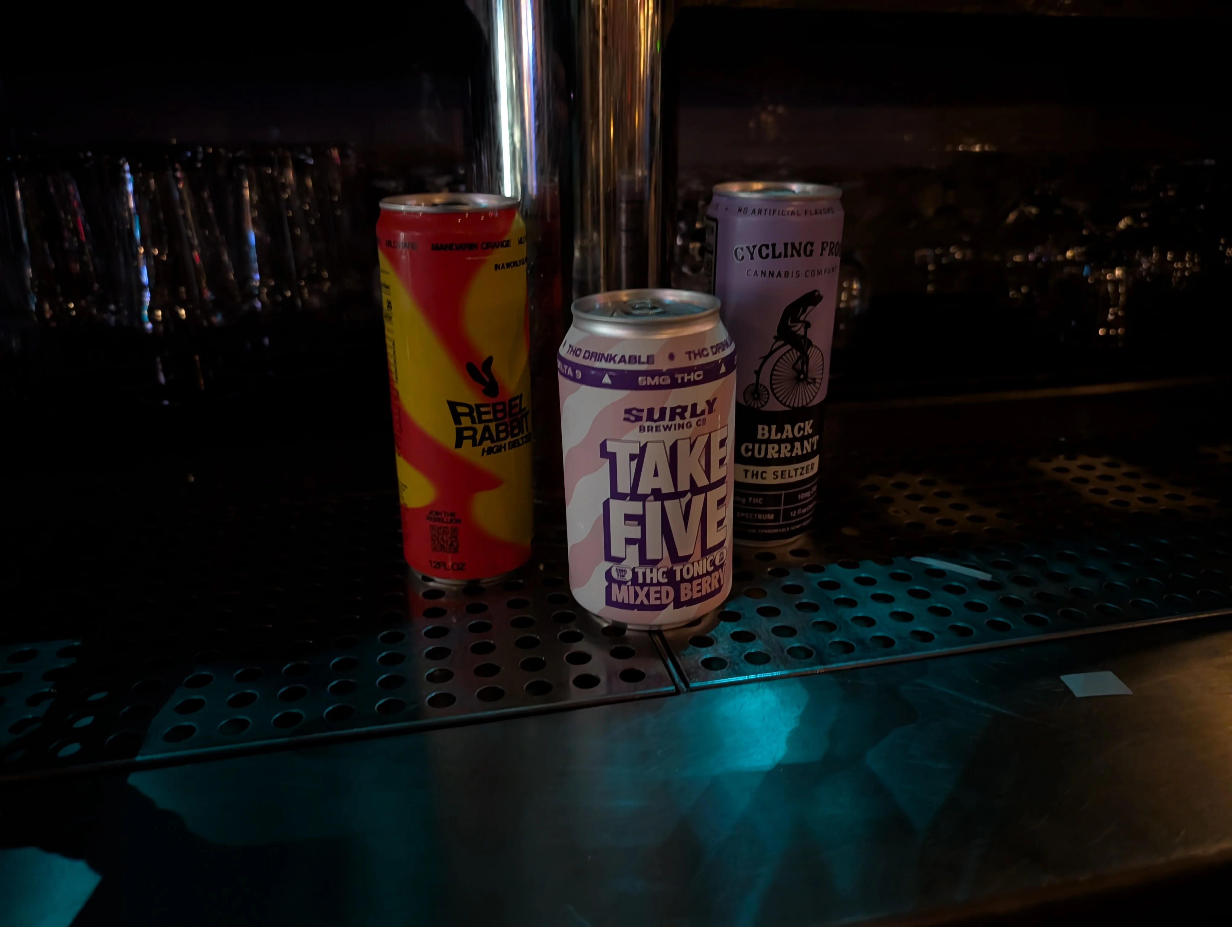 Variety of THC-infused beverages on a bar counter