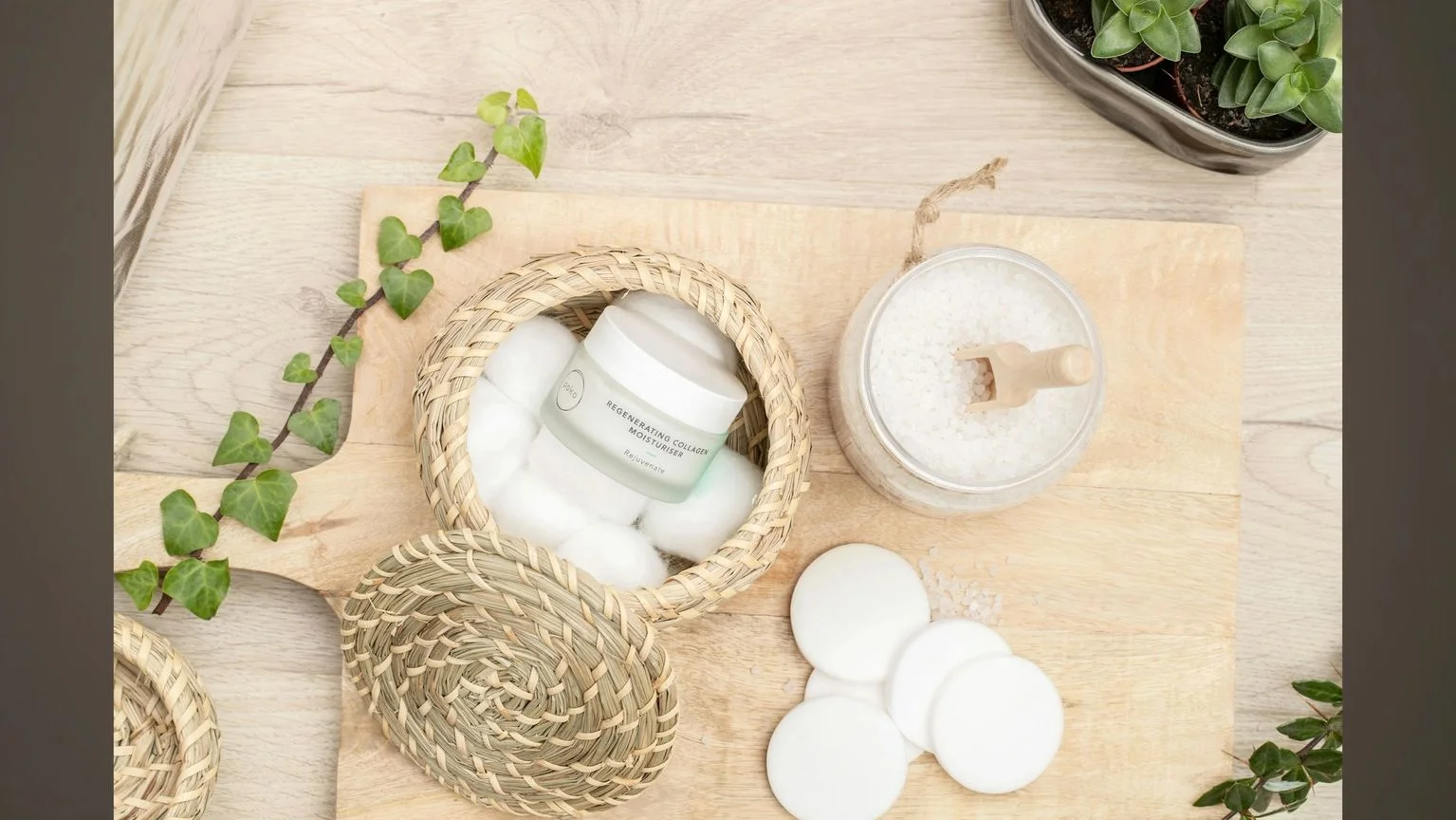 Natural skincare products and cotton pads arranged on a wooden surface.
