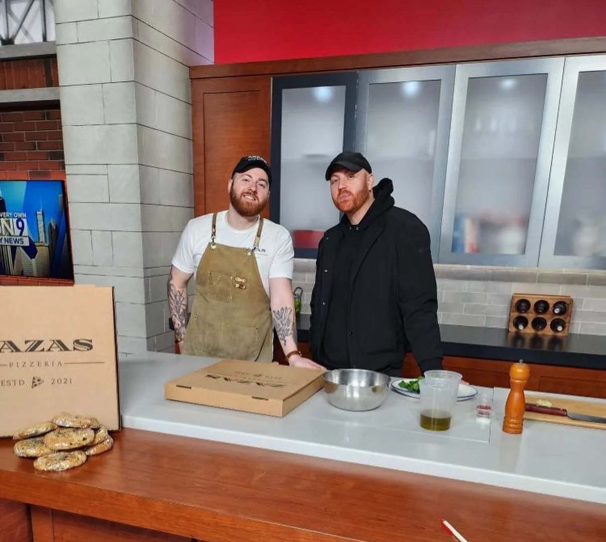 Chefs preparing pizza in a modern kitchen studio