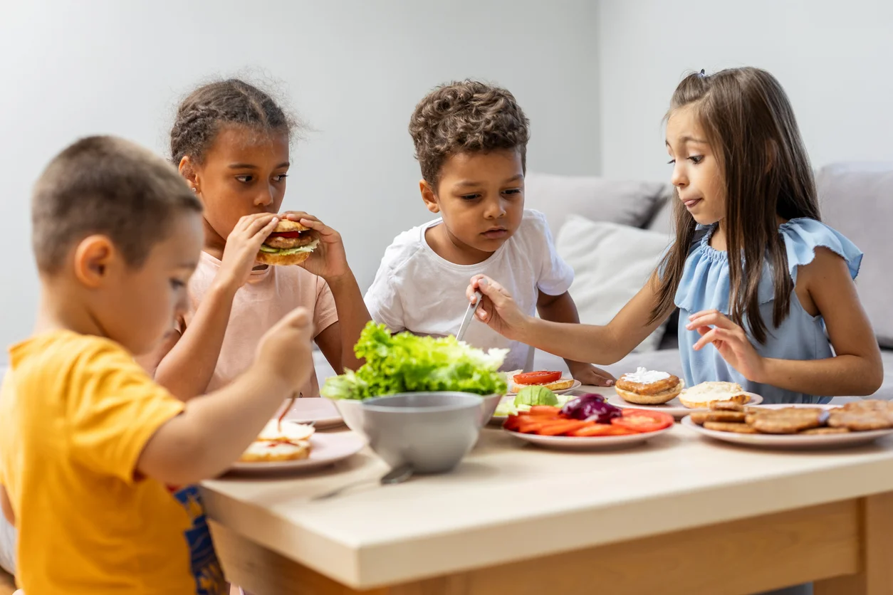 Children enjoying homemade burgers at a dining table