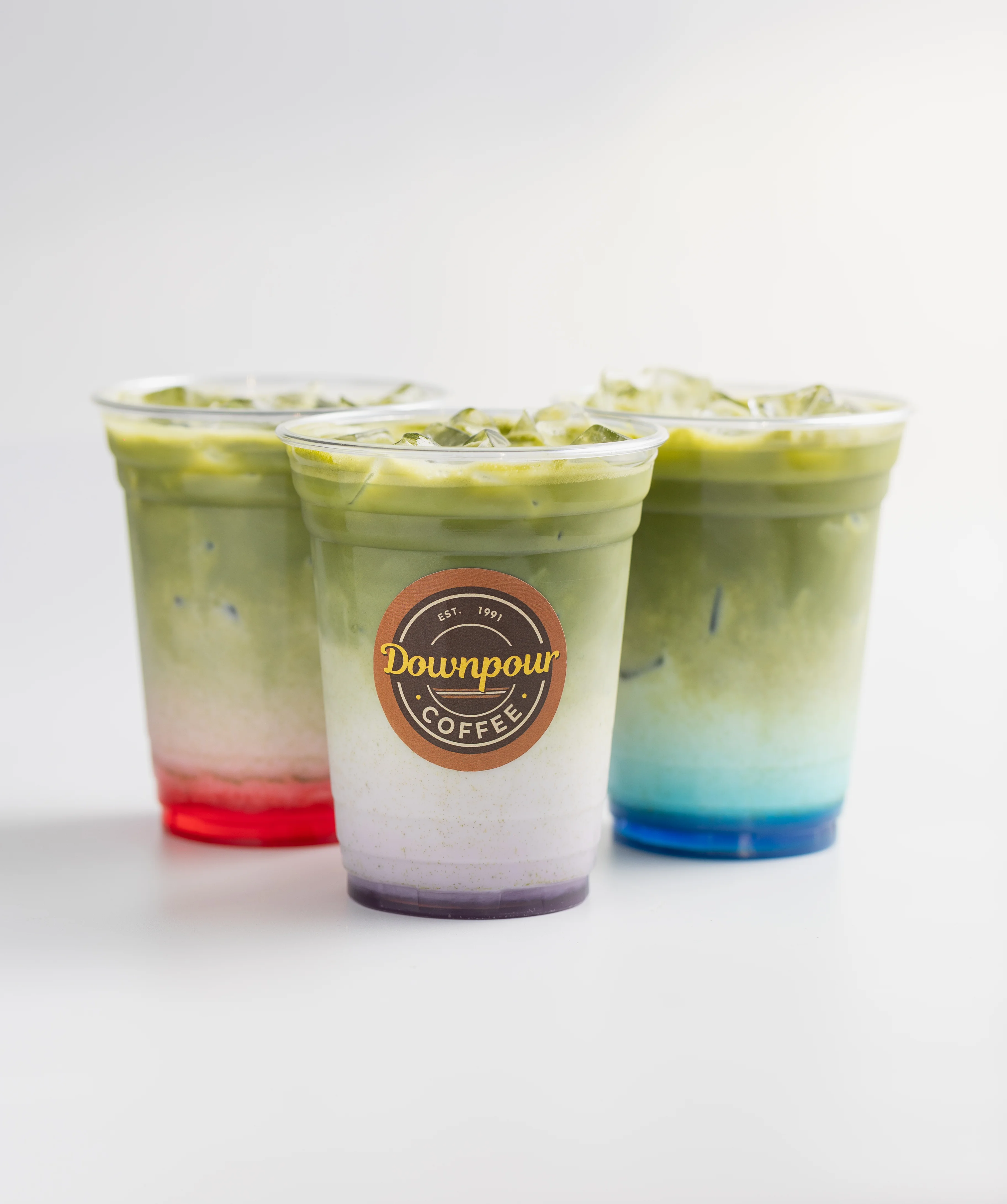 Colorful matcha drinks in clear cups from Downpour Coffee