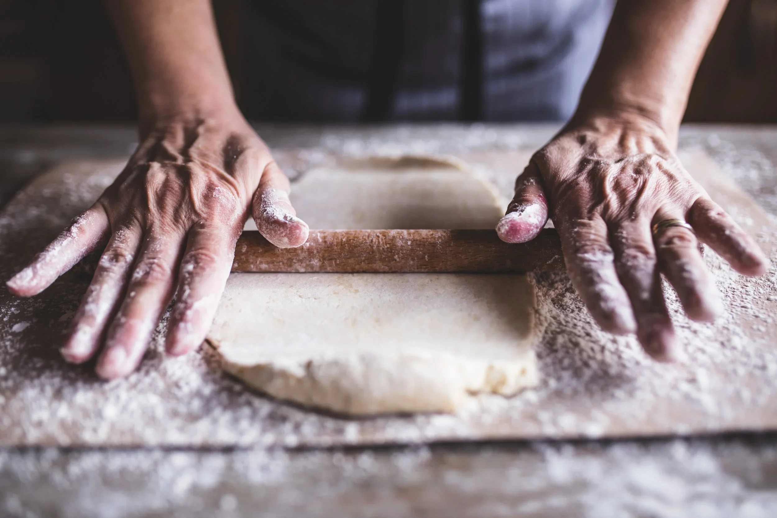 A freshly baked rolling pin with flour on a wooden surface.
