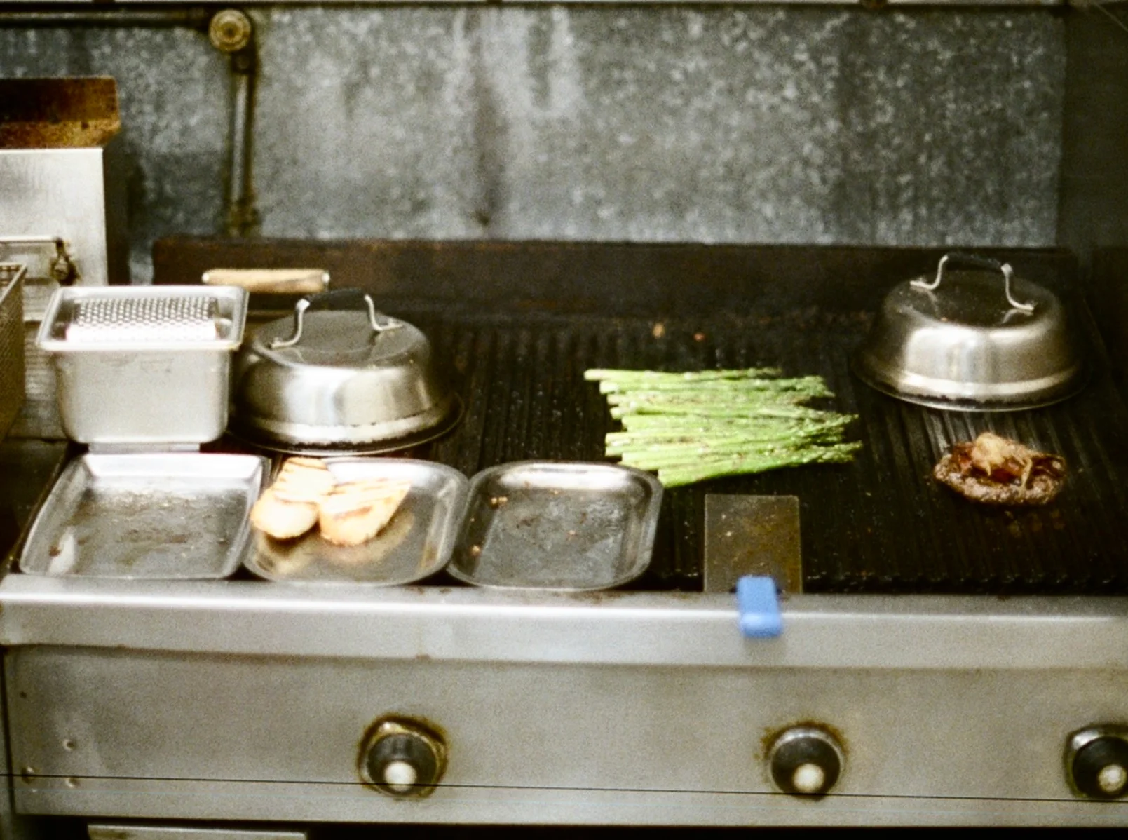 Grill station with asparagus and steak in a restaurant kitchen