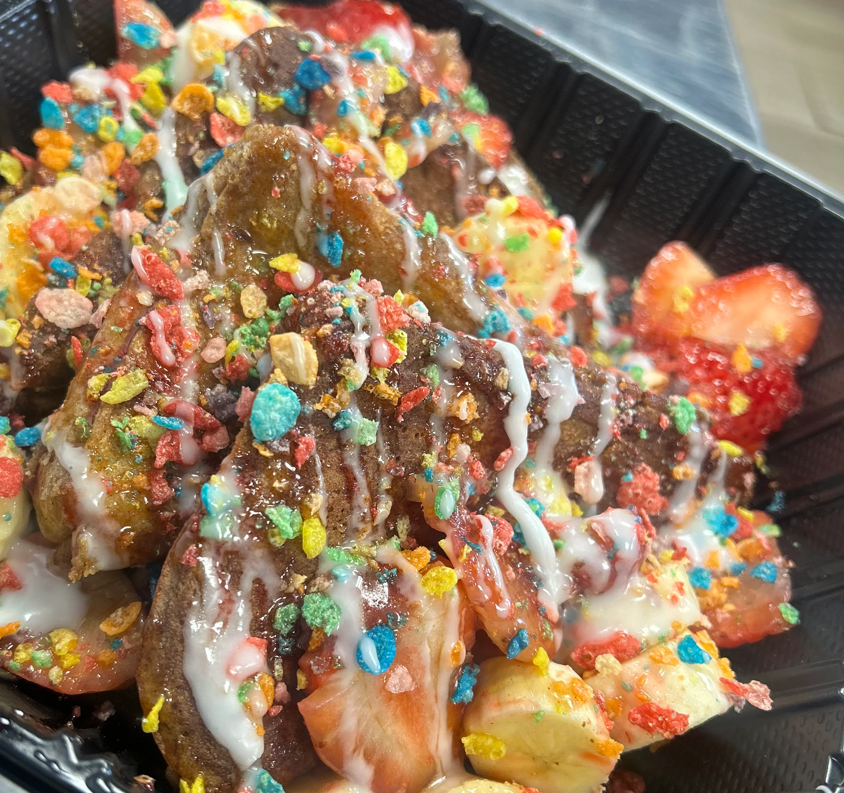 Colorful dessert nachos topped with fruit and candy