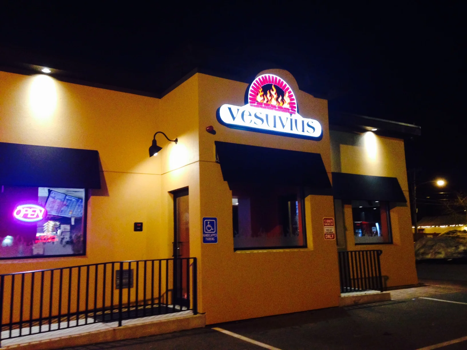 Vesuvio's restaurant exterior at night with neon signs