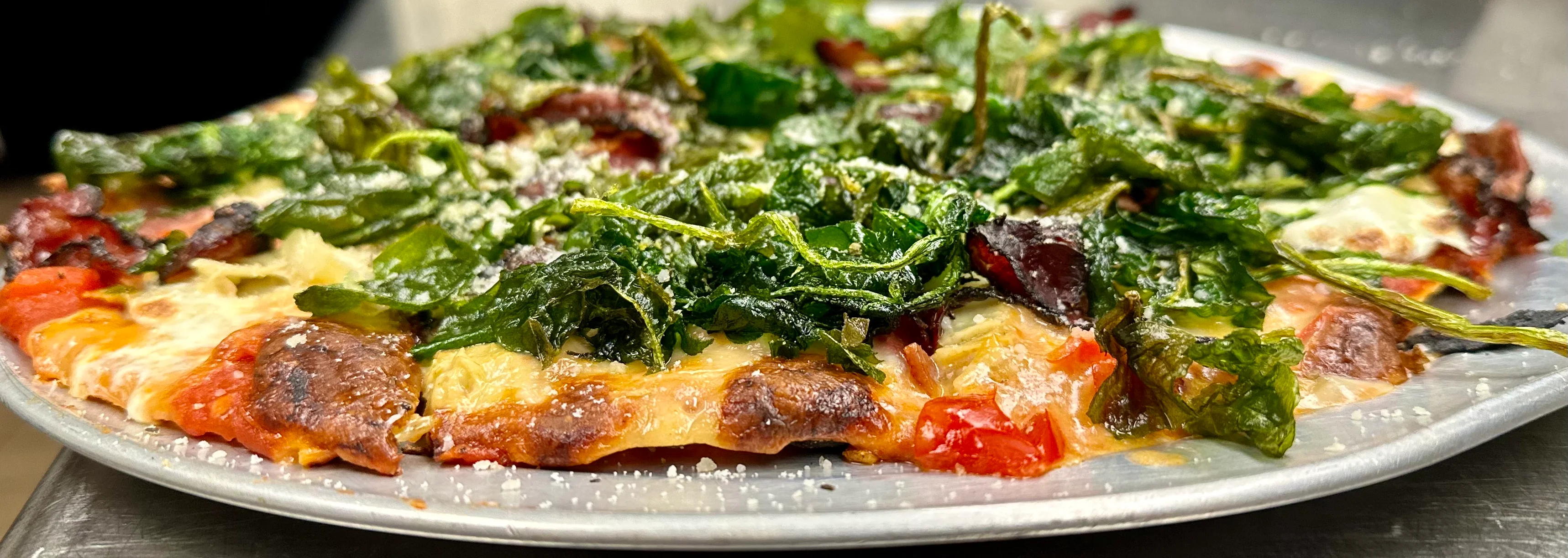 Freshly baked pizza topped with sautéed greens