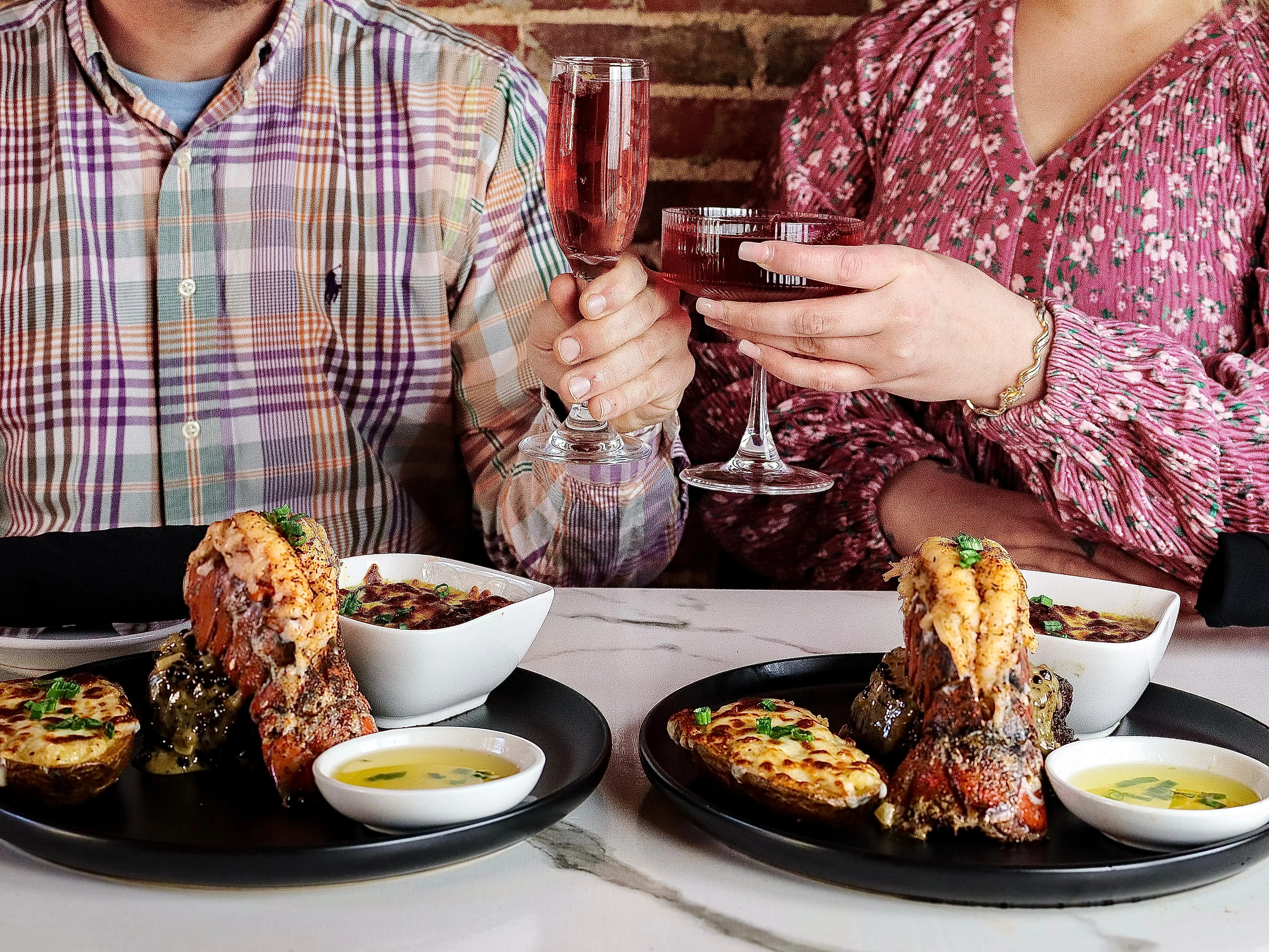 Grilled lobster tail with sides in a cozy restaurant setting