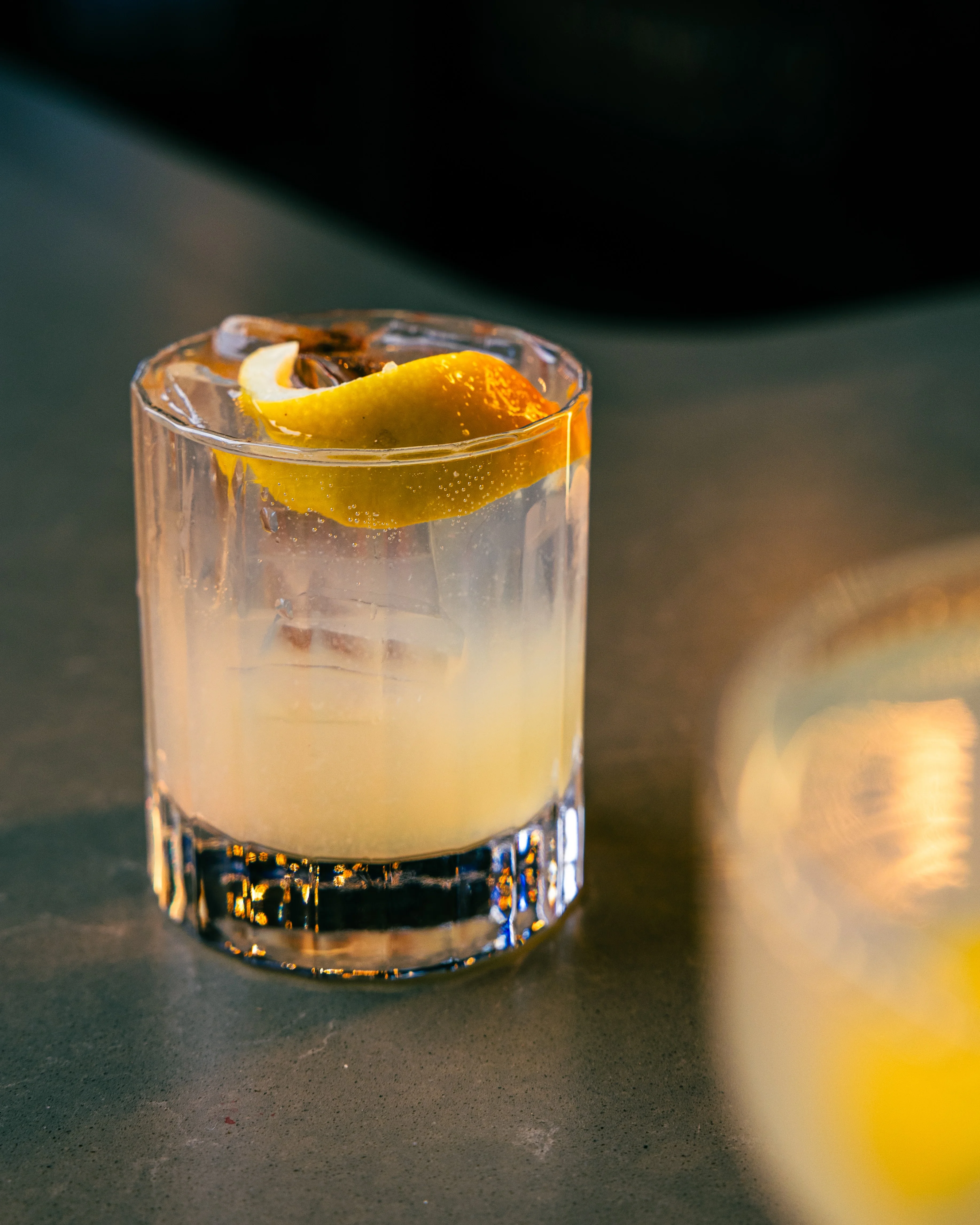 Refreshing cocktail with lemon garnish on a bar counter