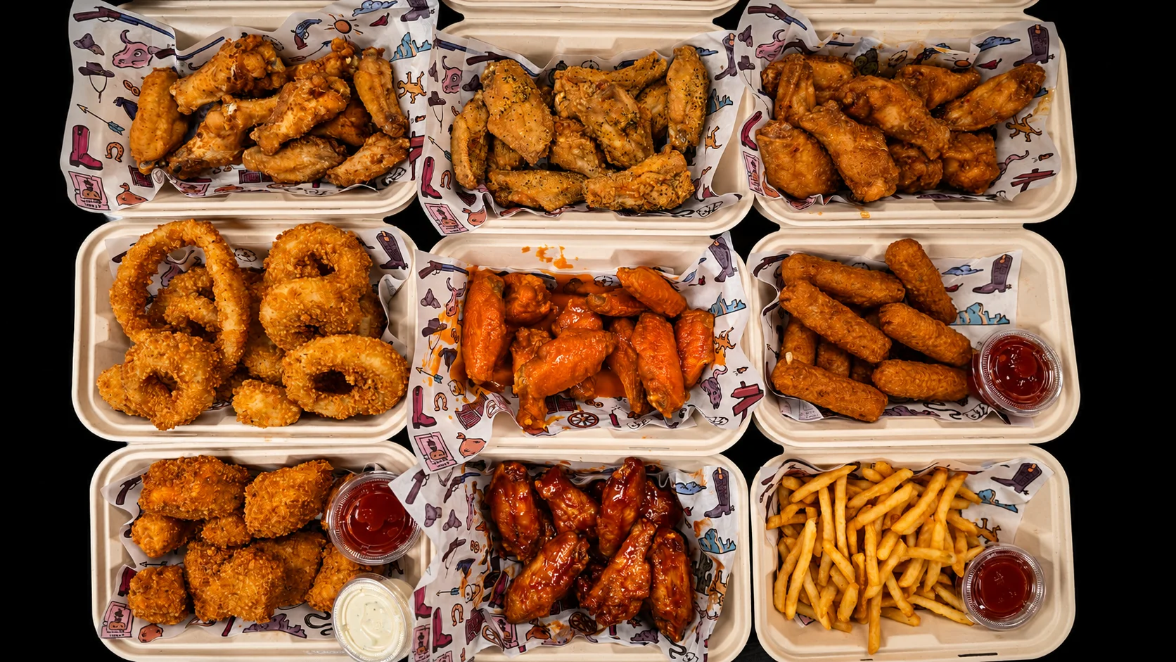 Assorted chicken wings and onion rings in takeout containers