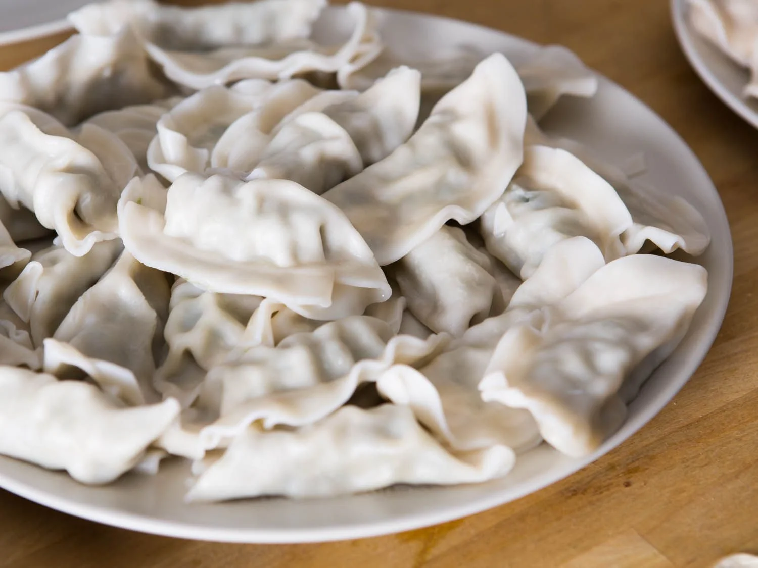 A plate of freshly made dumplings arranged neatly.