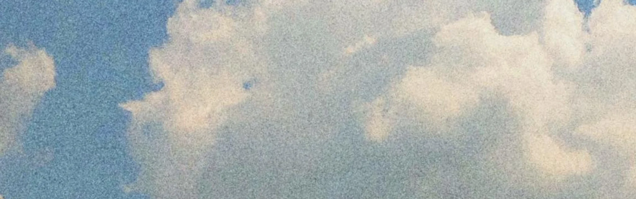 Fluffy white clouds against a blue sky