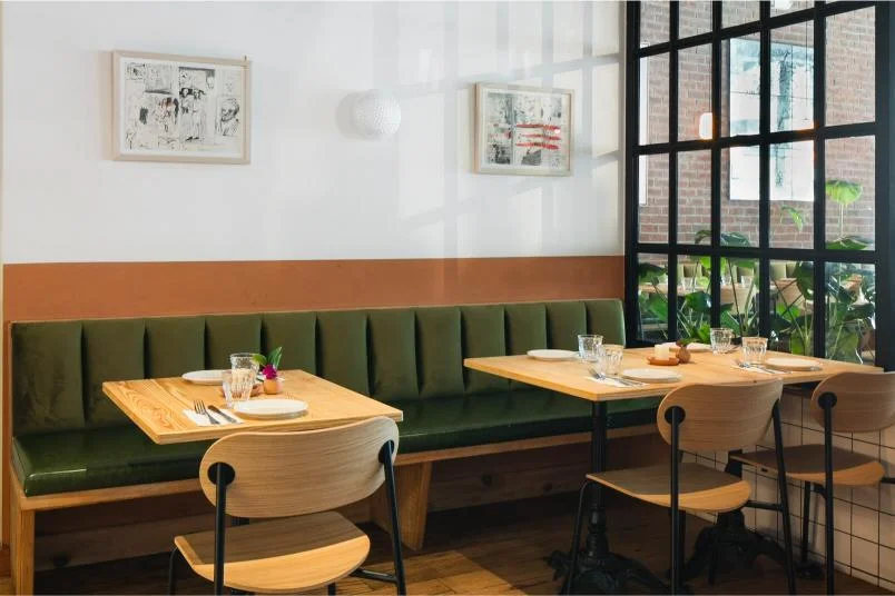Cozy restaurant interior with green seating and natural light
