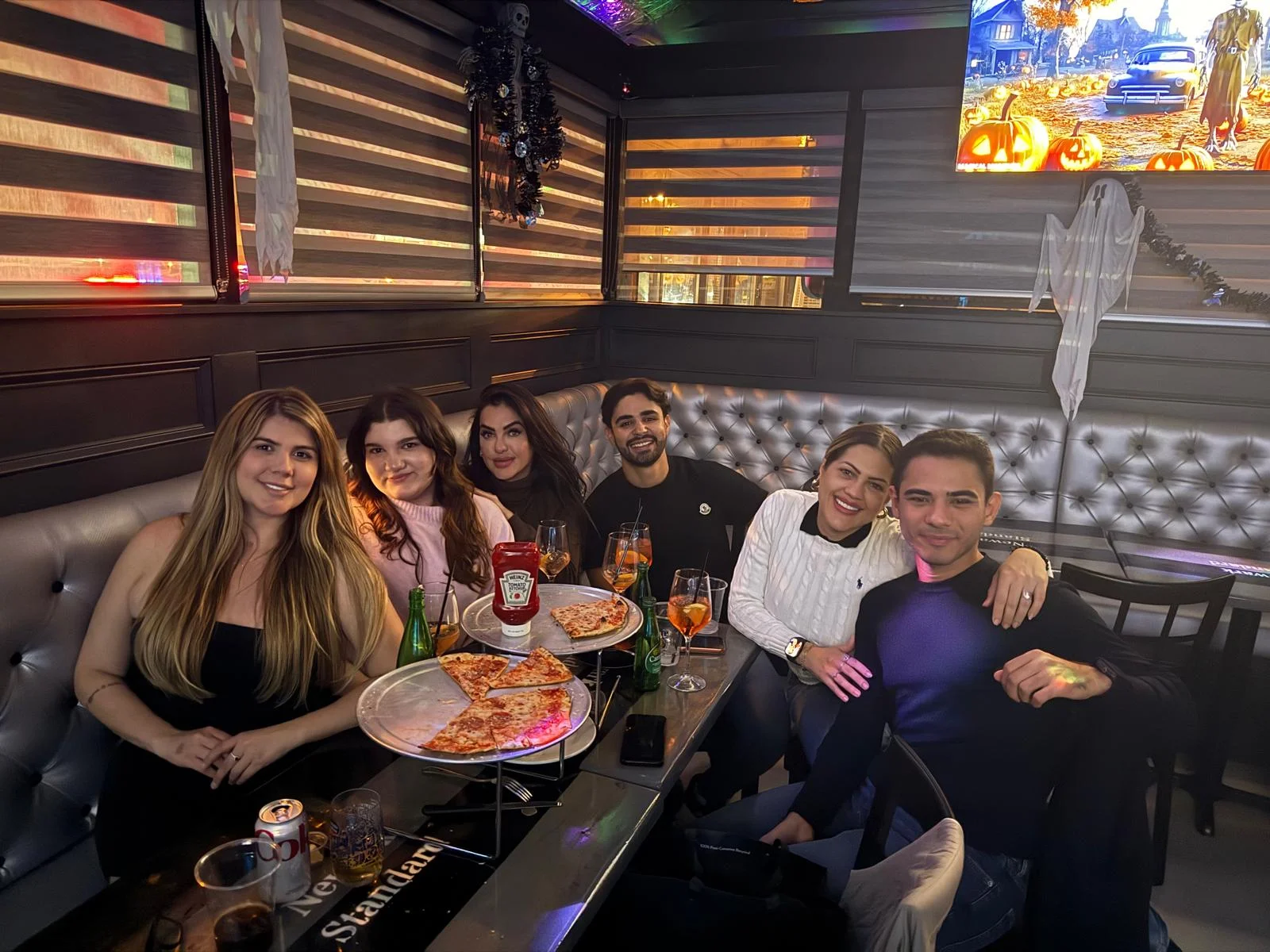 Group of friends enjoying pizza and drinks at The Newark Standard Restaurant Bar Cafe