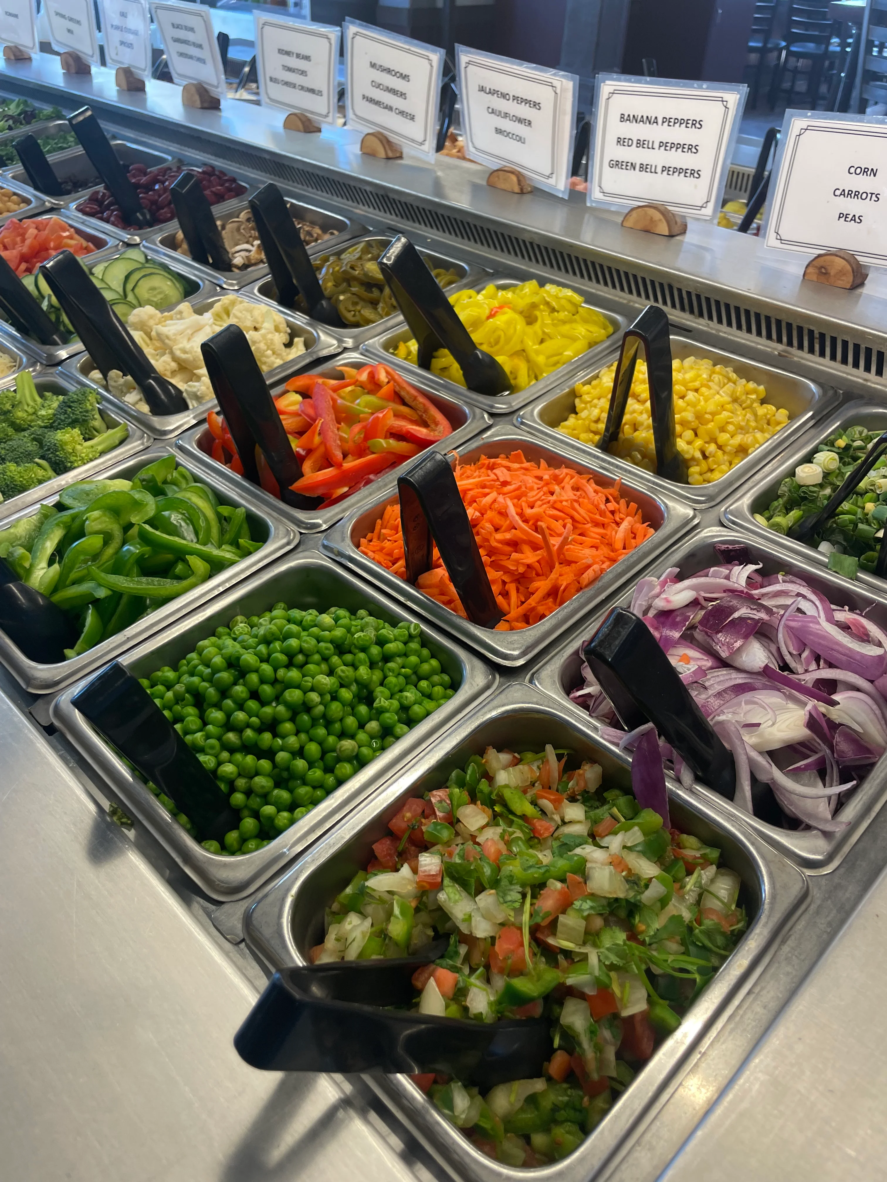 Fresh vegetable salad bar with diverse toppings