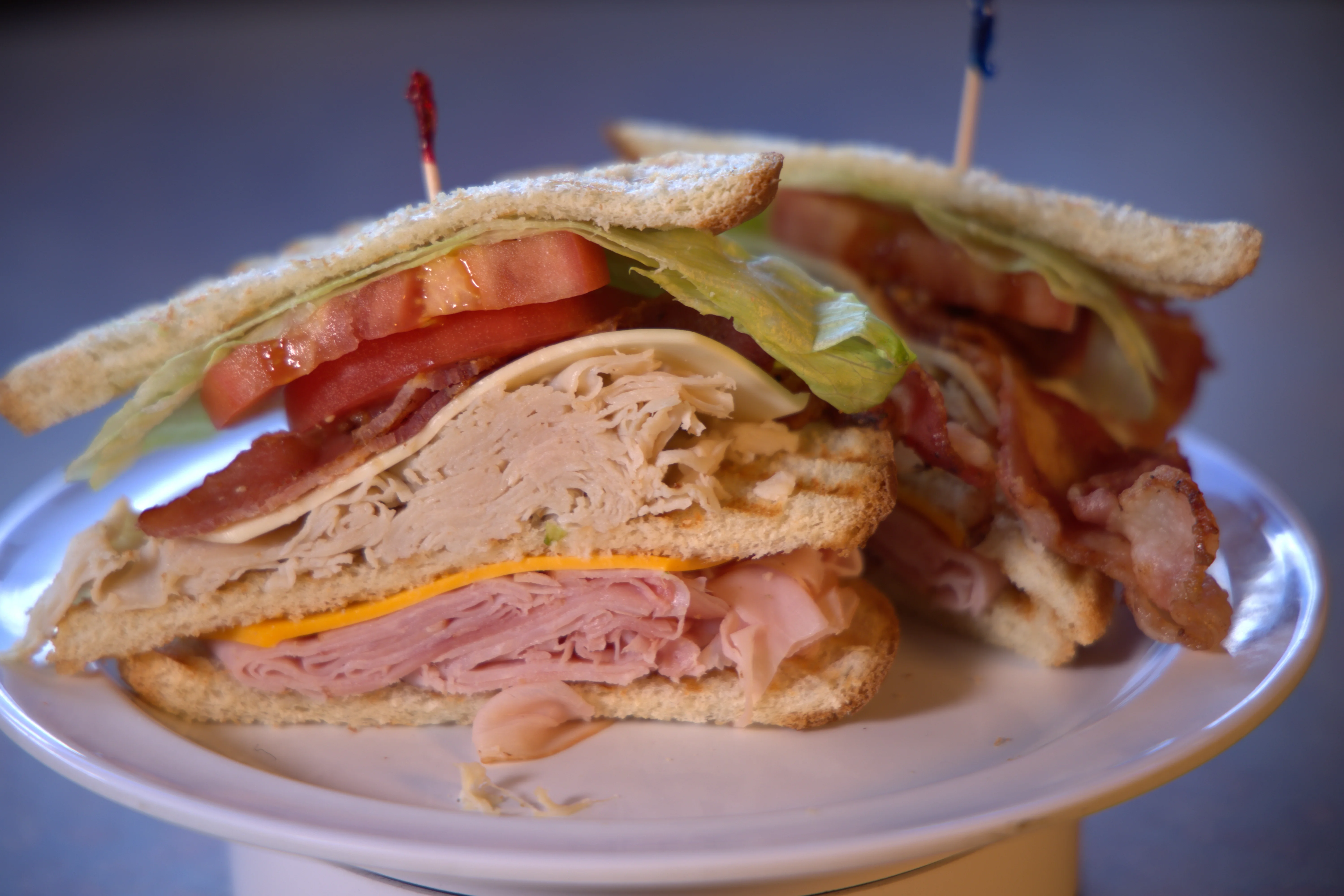 A delicious sandwich stacked with meats, cheese, lettuce, and tomatoes.
