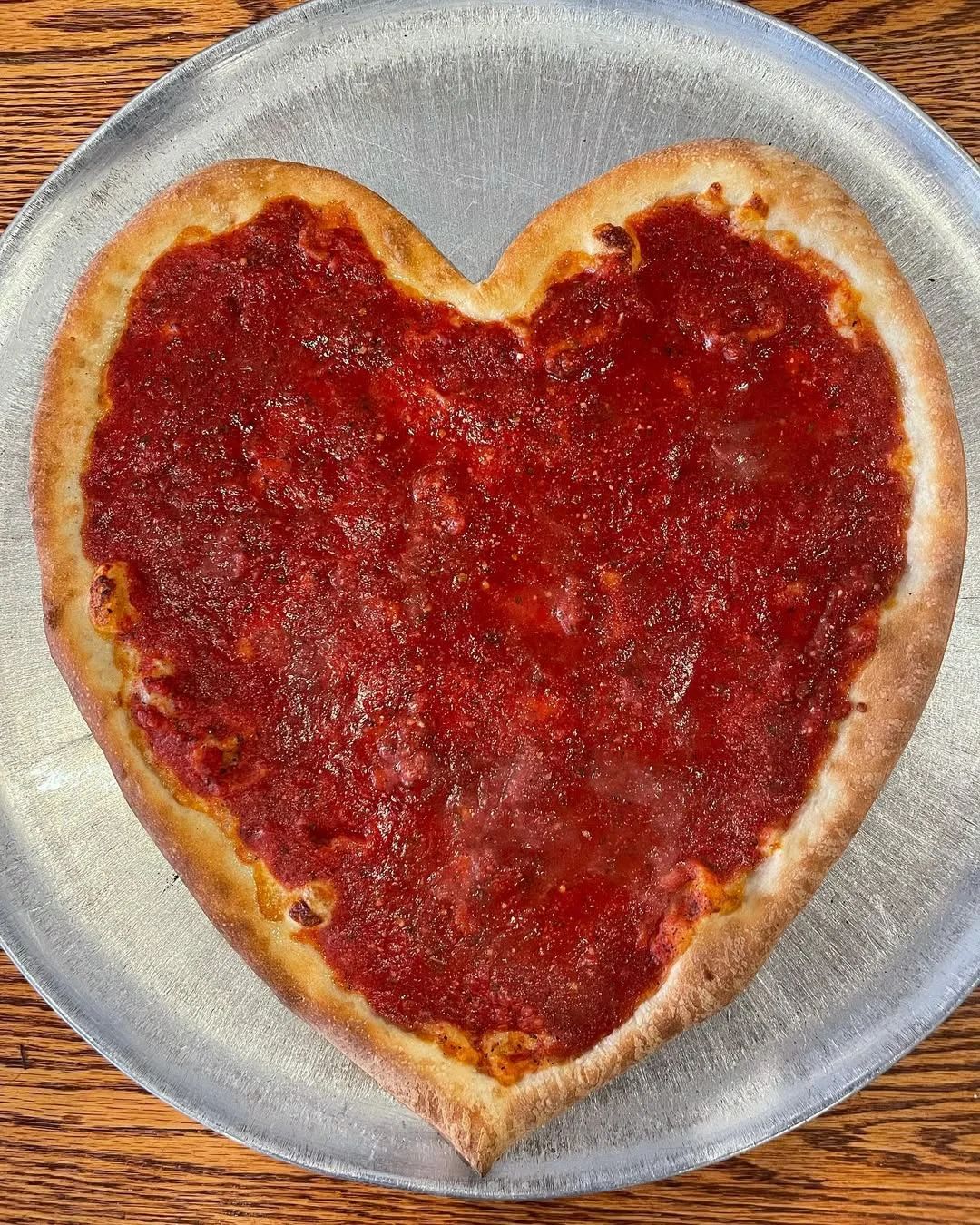 Heart-shaped pizza with rich tomato sauce