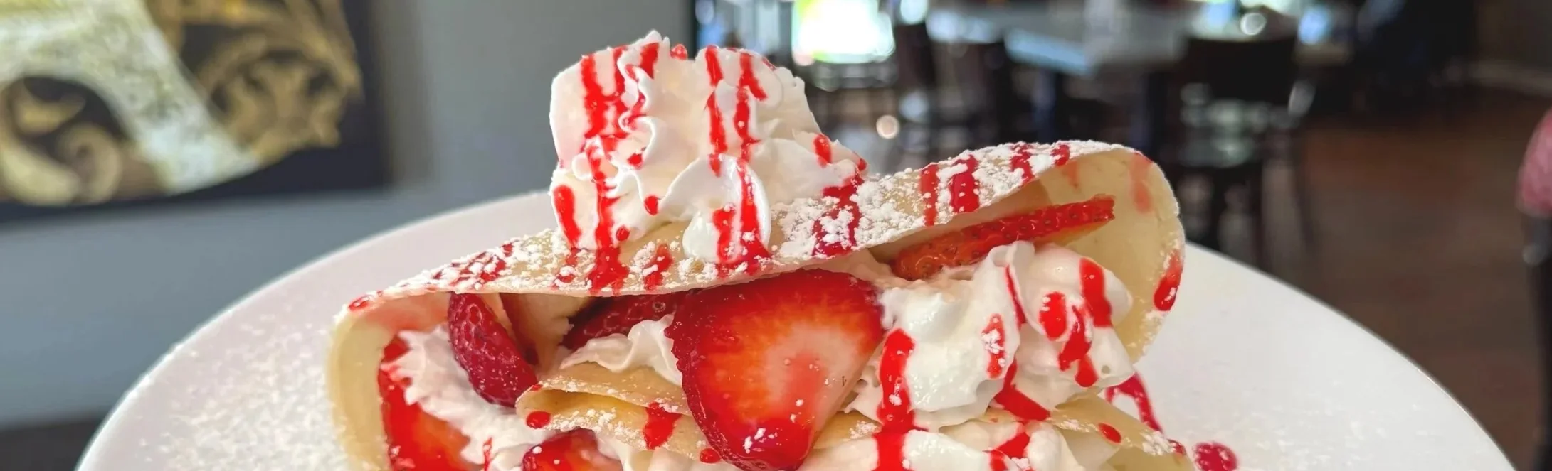 Delicious strawberry crepes topped with whipped cream