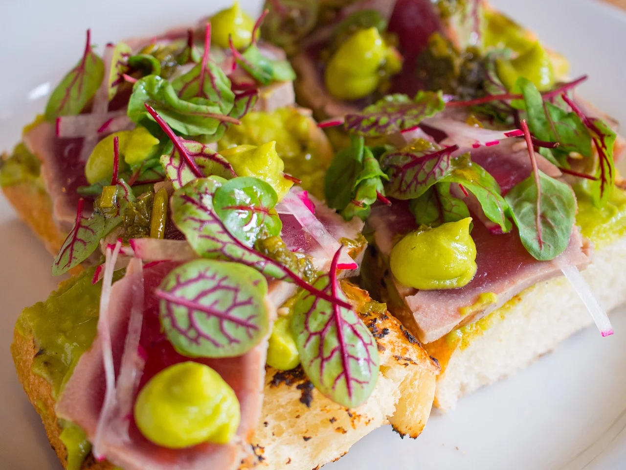 Open-faced tuna tartare on toasted bread with greens