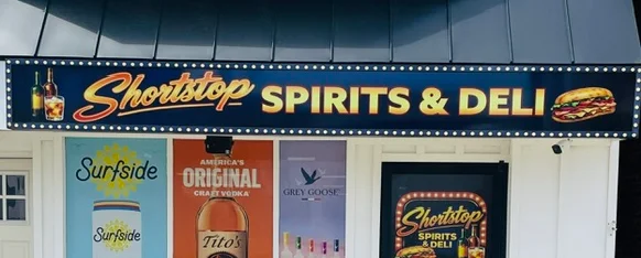 Exterior of Shortstop Spirits & Deli with signage and promotional banners.
