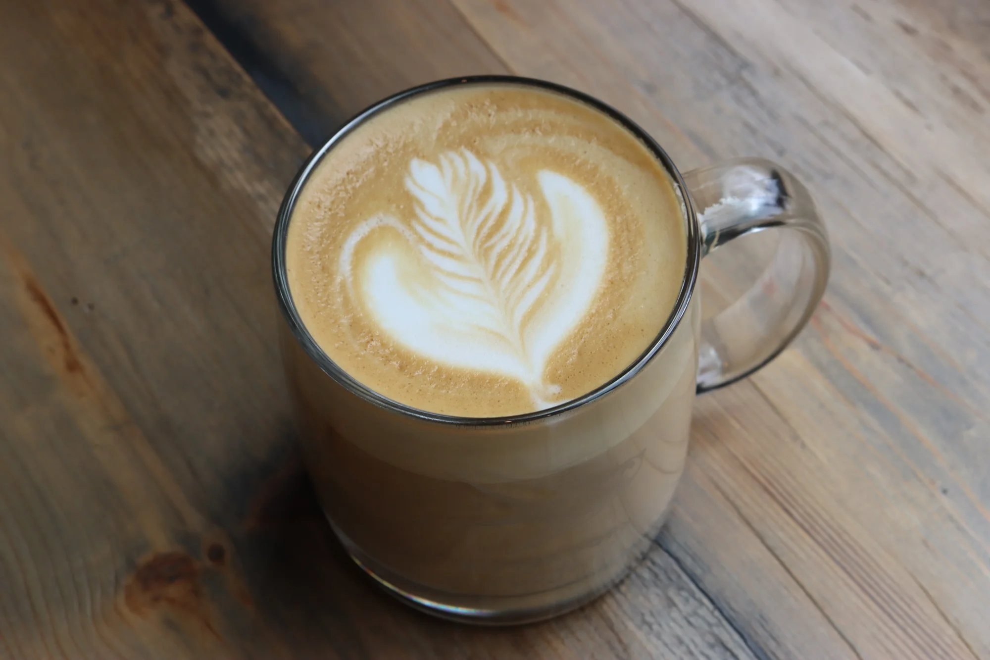 Creamy latte art in a glass mug