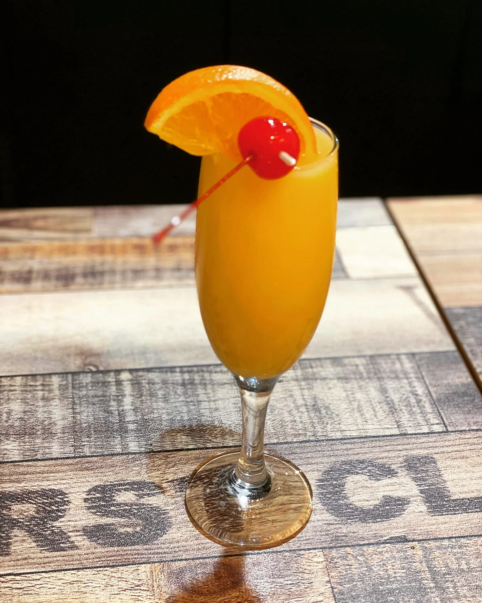 Refreshing mimosa cocktail with orange and cherry garnish