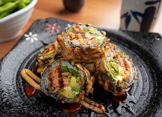 Crispy Japanese tempura sushi rolls on a decorative plate