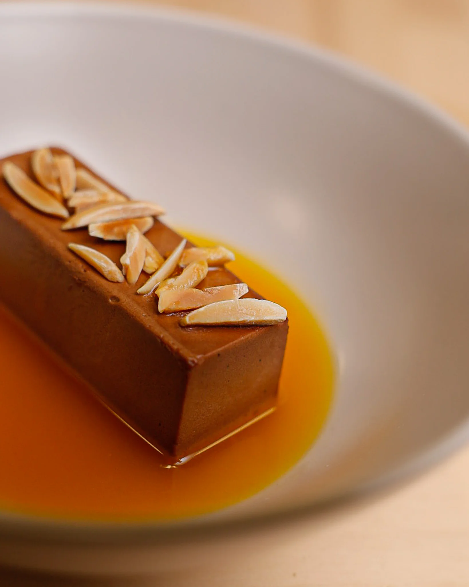 Silky chocolate mousse with caramel sauce and almond slivers
