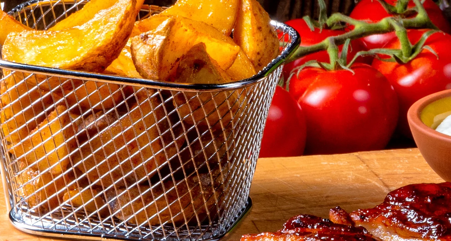 BBQ ribs served with crispy fries and fresh salad in a rustic setting