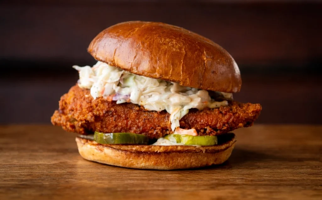 Delicious gourmet burger with fresh toppings on a wooden table.