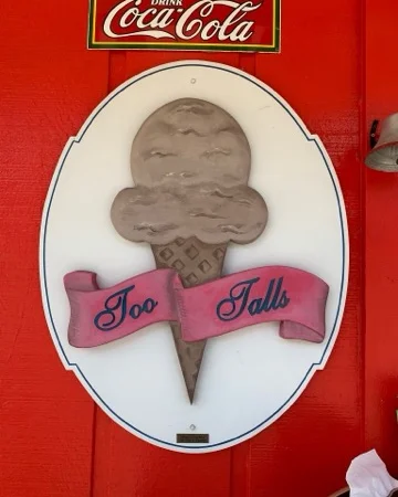 Ice cream shop sign featuring a cone and the name 'Too Talls'