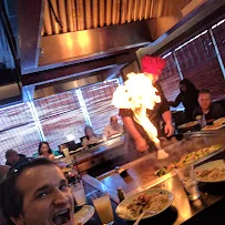 Teppanyaki chef performing a flame show at a lively restaurant