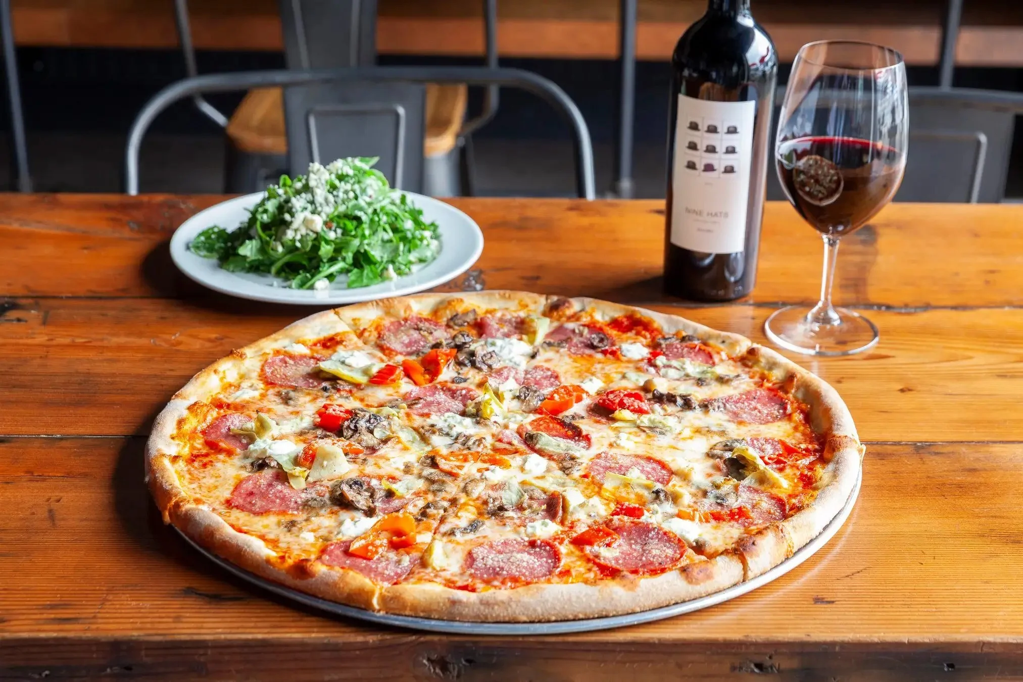 Delicious pepperoni pizza served with a fresh arugula salad
