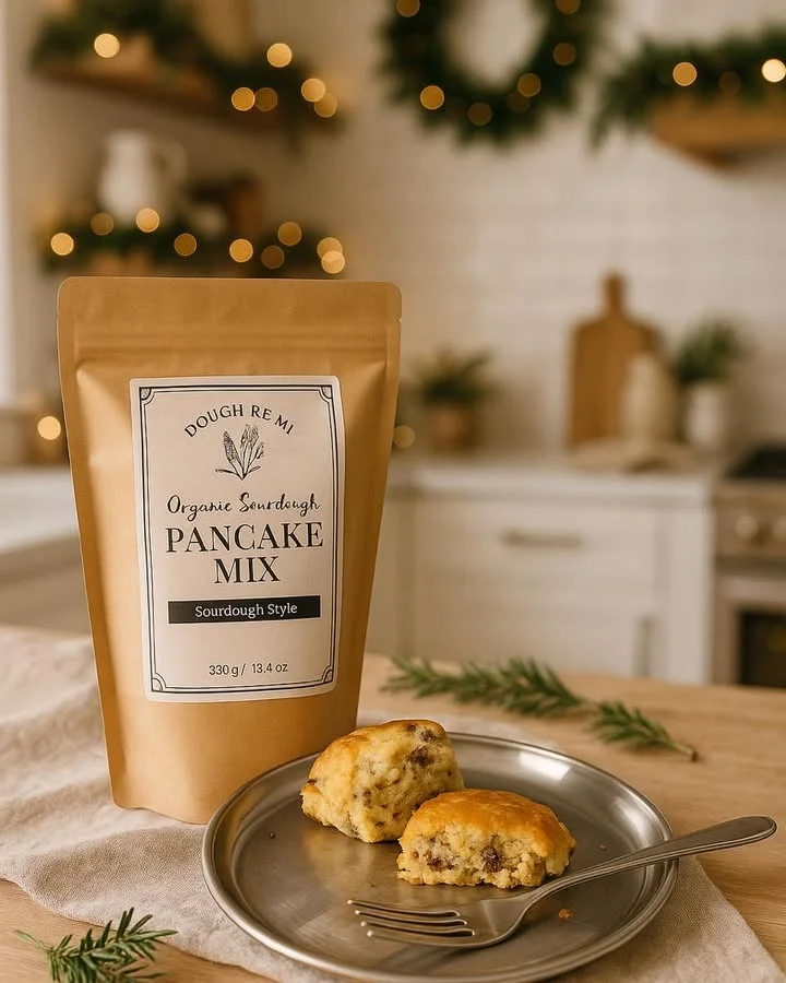 A package of organic sourdough pancake mix sits on a table next to freshly baked biscuit pieces.
