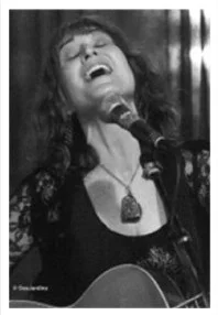 Singer performing passionately with guitar on stage