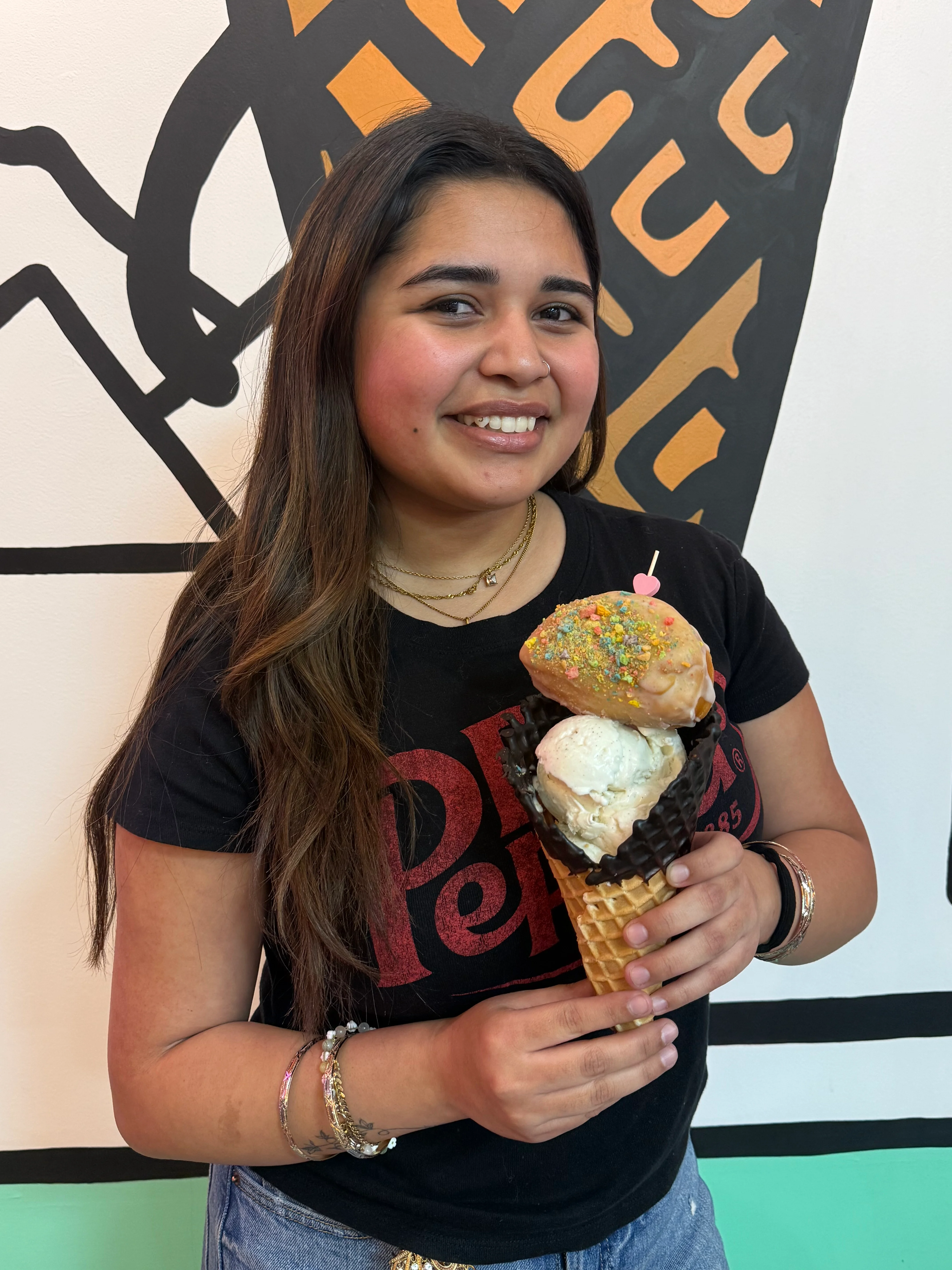 Delicious ice cream cone topped with a donut and colorful sprinkles