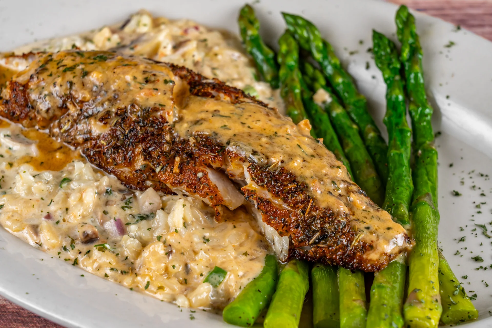 Blackened fish with creamy risotto and asparagus, showcasing Southern cuisine
