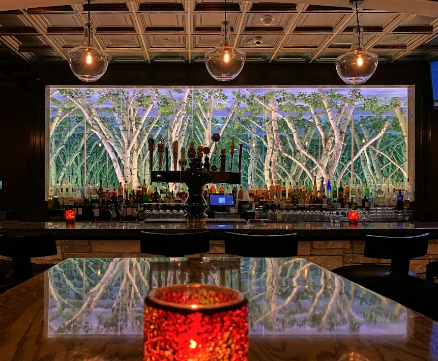 Stylish bar interior with a nature-themed backdrop