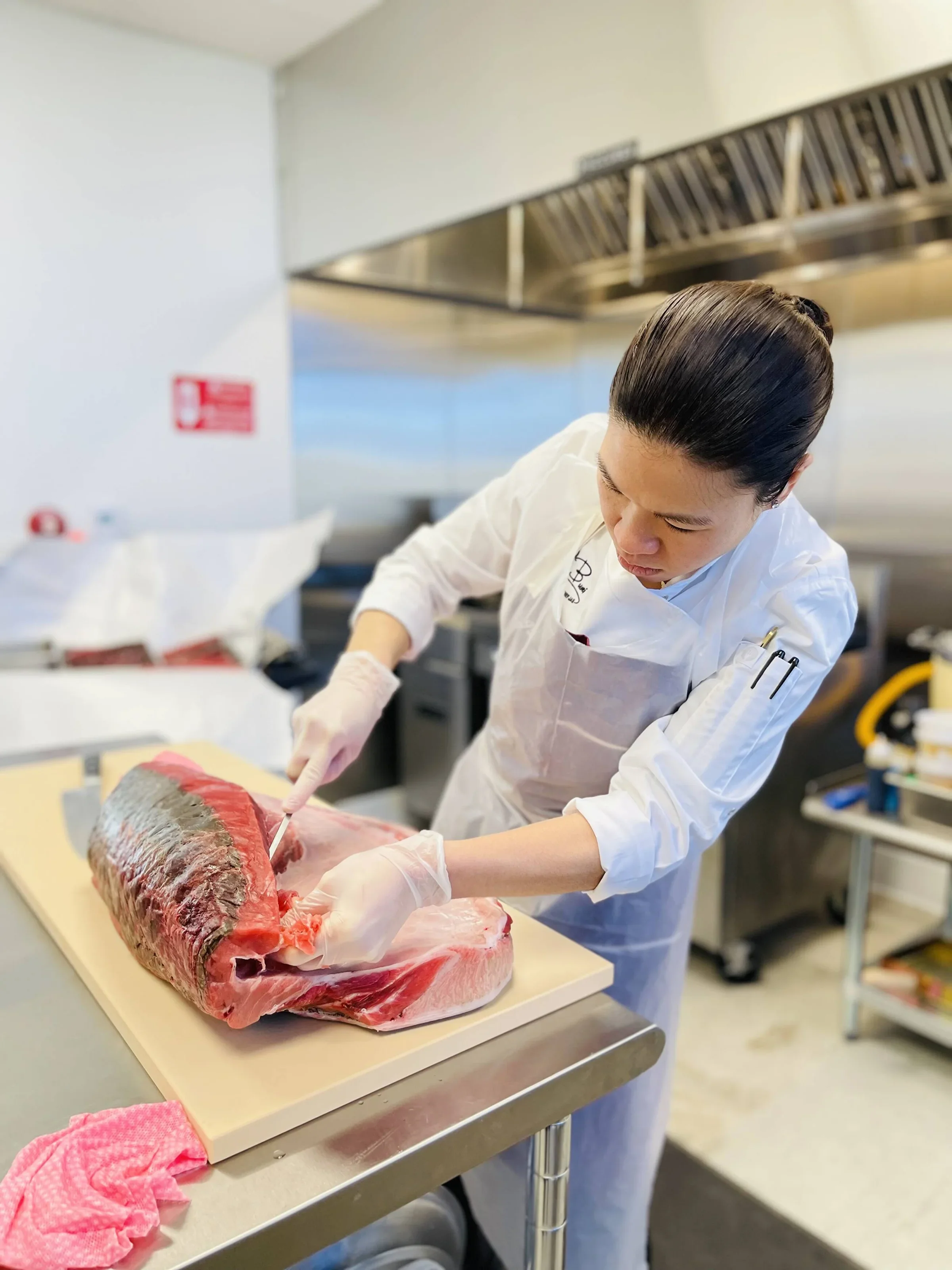 Chef skillfully filleting a large fish in a professional kitchen