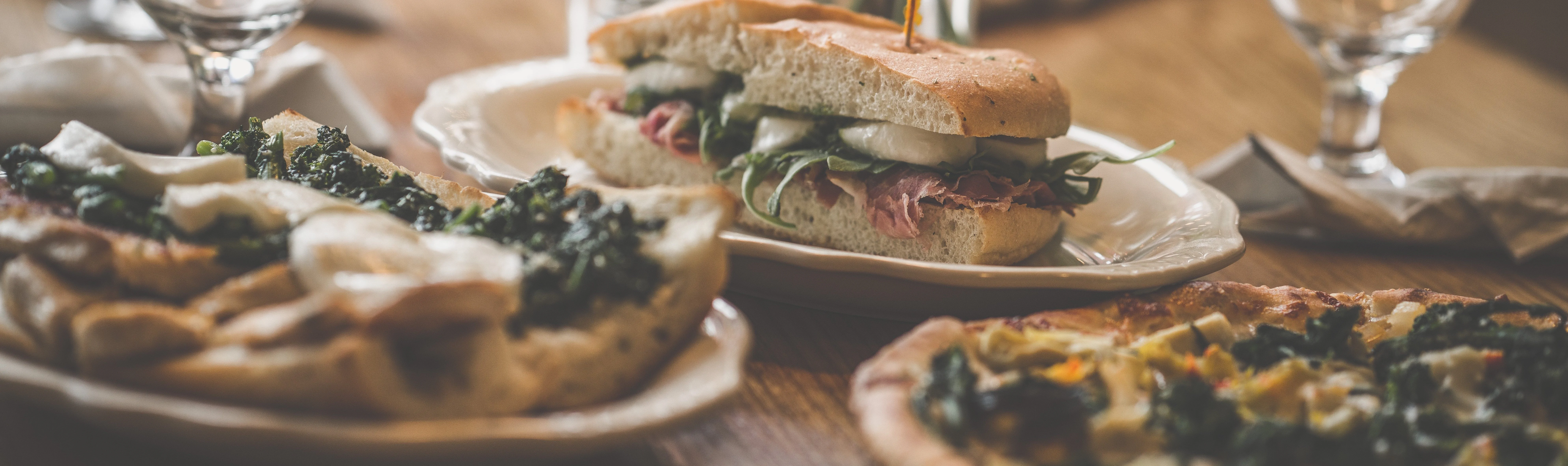 Italian sandwich and pizza on a rustic wooden table