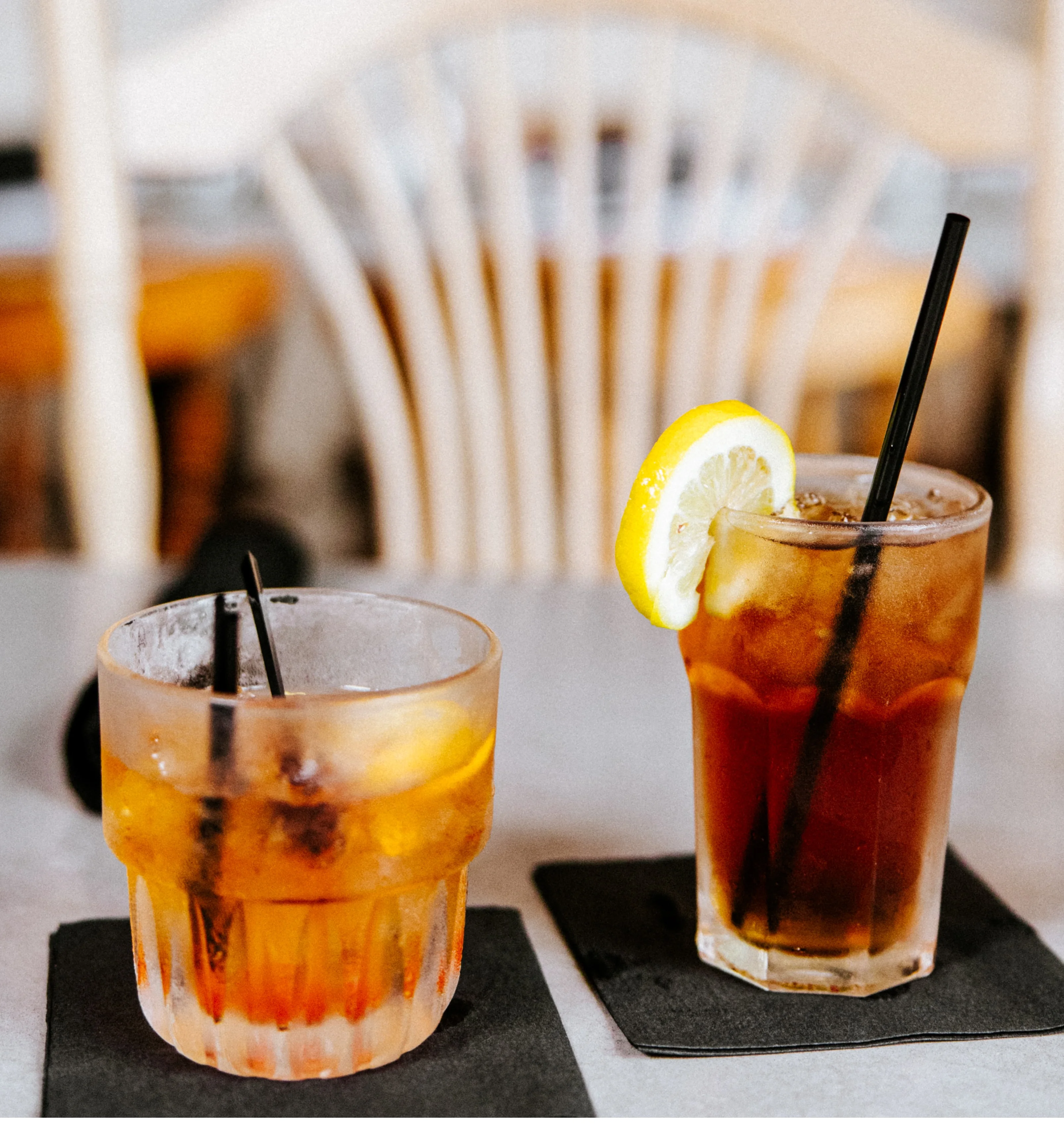 Amber cocktails with citrus garnish served at a restaurant bar