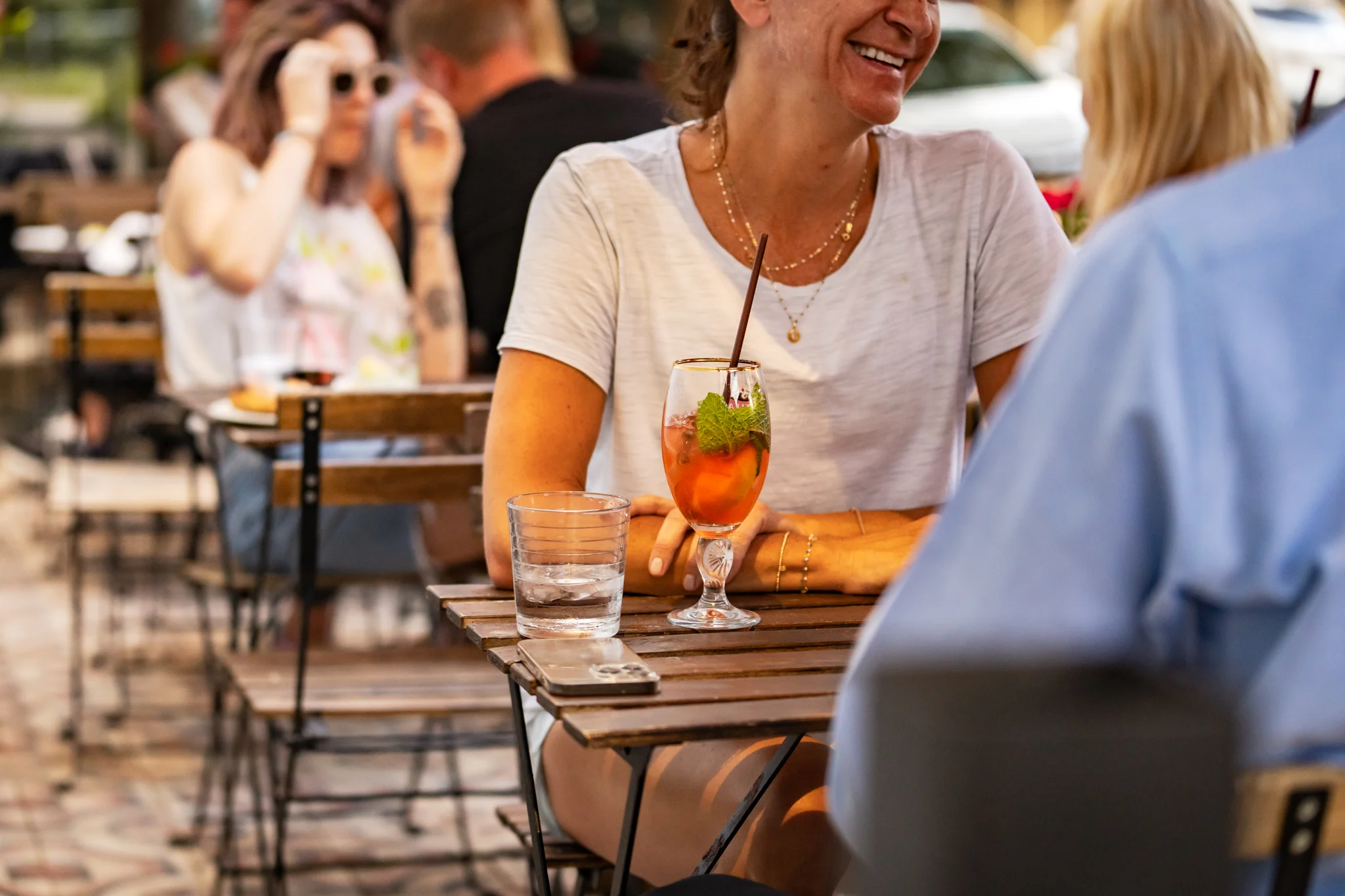 Outdoor dining scene with cocktails and laughter