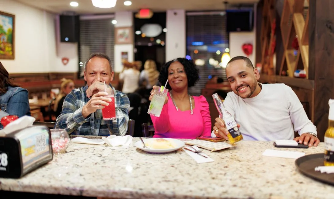Group of friends enjoying drinks at a restaurant bar.