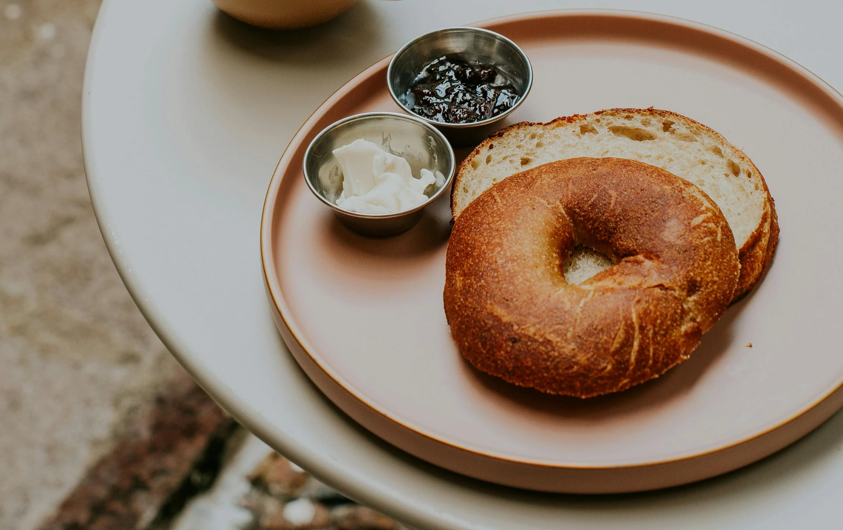 Freshly brewed latte with a bagel and cream cheese