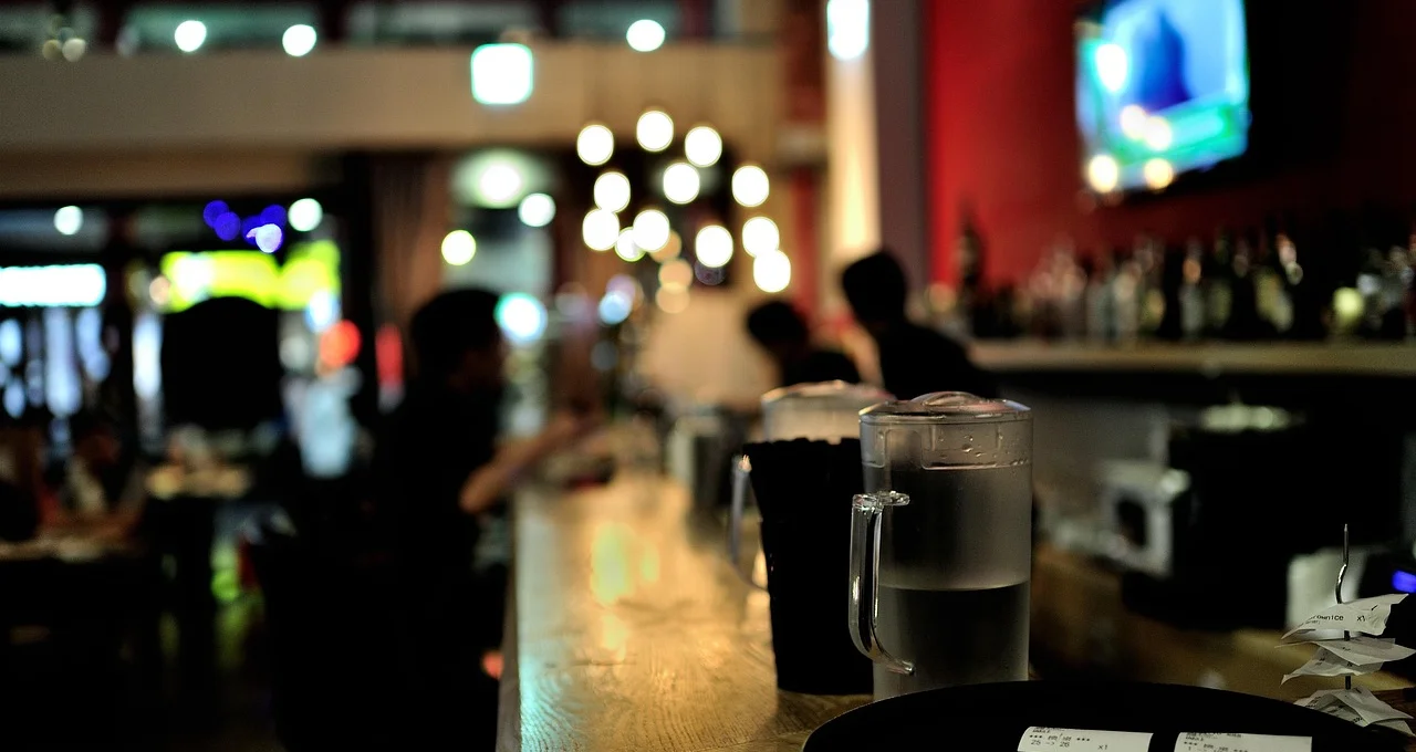 Modern bar interior with water pitchers and warm lighting