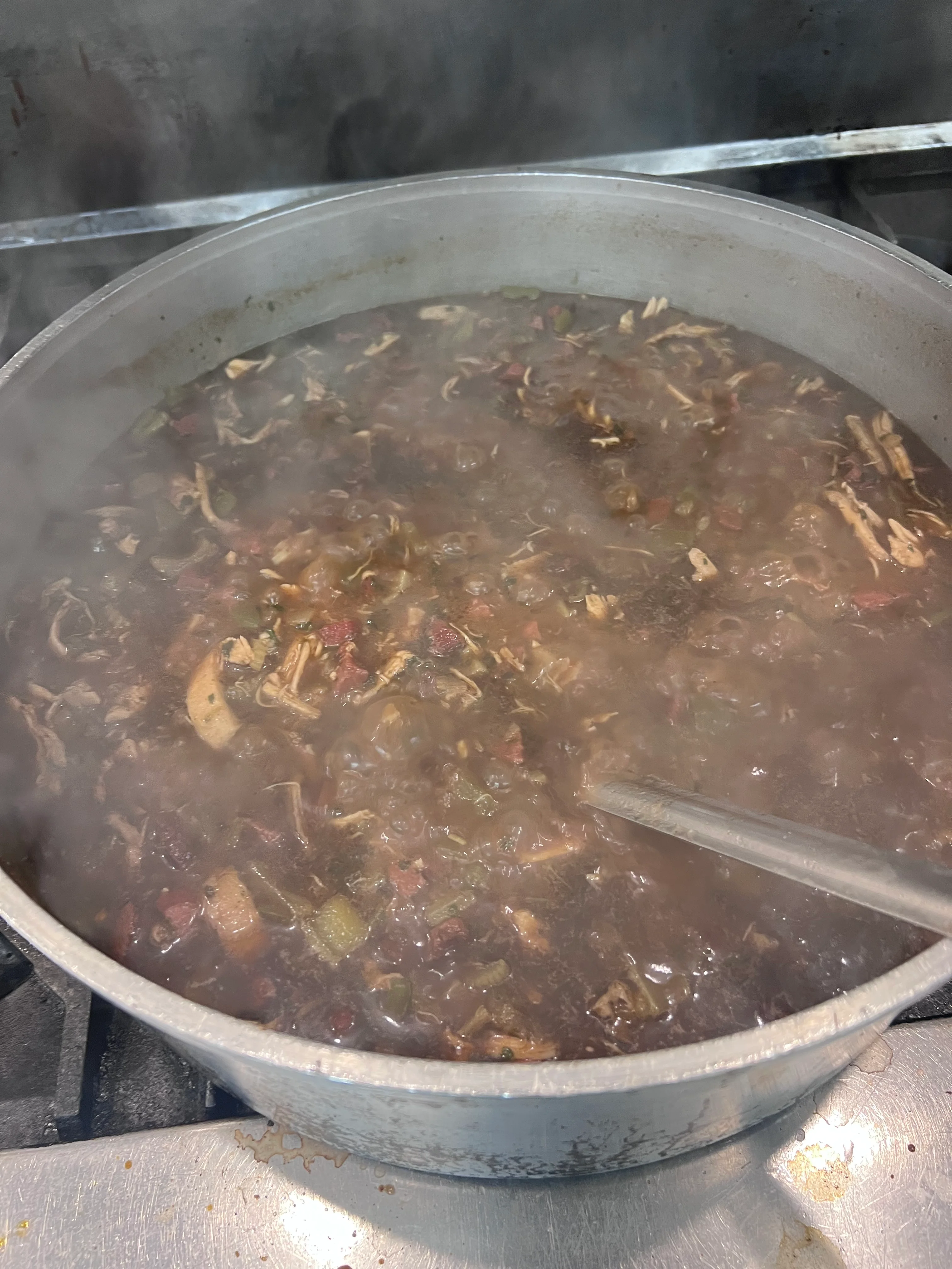 Steaming pot of gumbo simmering on the stove