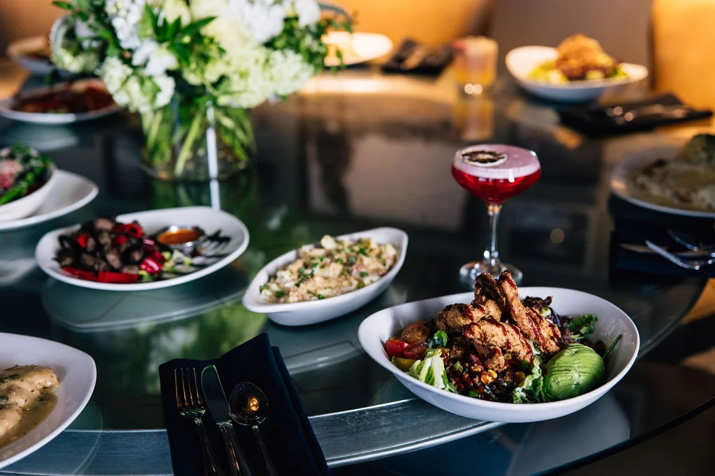 A beautifully arranged dining table with various dishes and a cocktail.