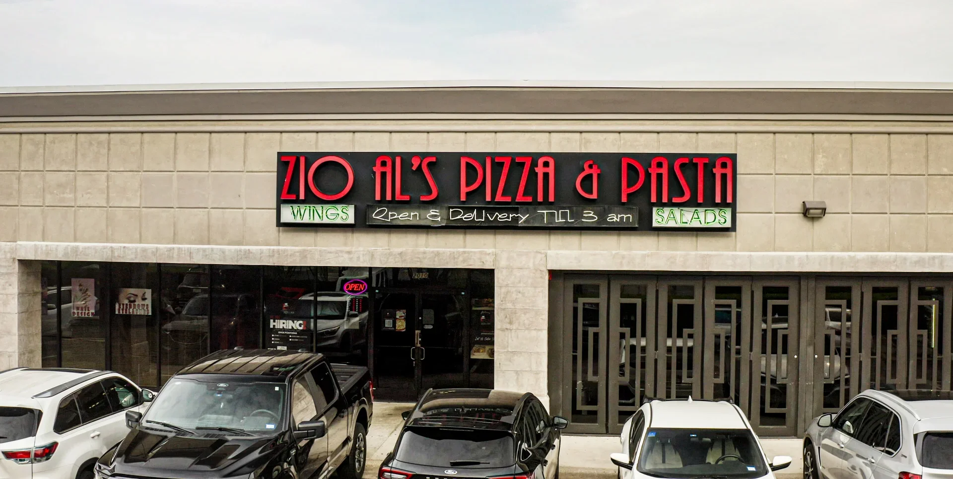 Exterior of Zio Al's Pizza & Pasta restaurant with neon signage
