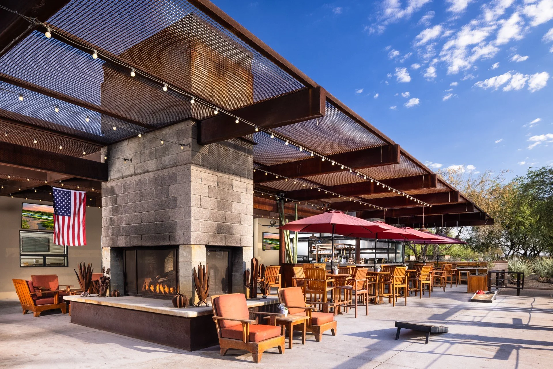 Stylish outdoor dining area with a fireplace and umbrellas